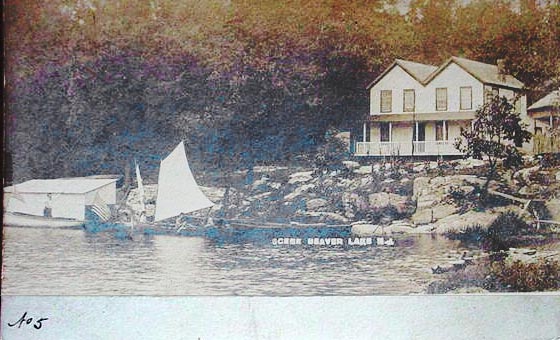 Beaver Lake - A view of a cottage and a sailboat - c 1910