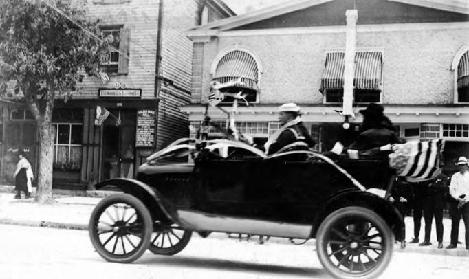 Egg Harbor City - Car in a parade - In the background is the Colonial Theater with the Golden Eagle Hall and the Egg Harbor City Telephone company exchange in the building which is now the Masonic Lodge - c 1910.jpg 